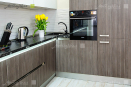 Мебель для кухни серо-коричневого цвета с белыми глянцевыми верхними фасадами.
